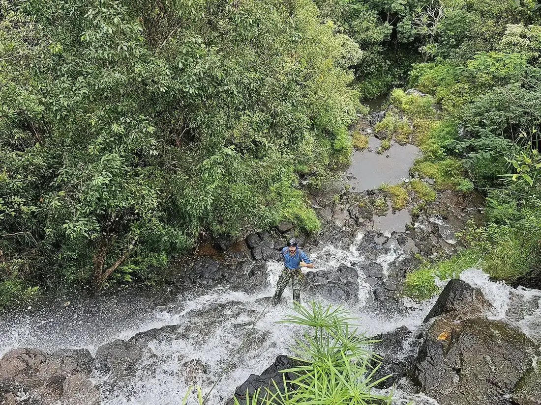 Looking down a rappel line into a jungle stream