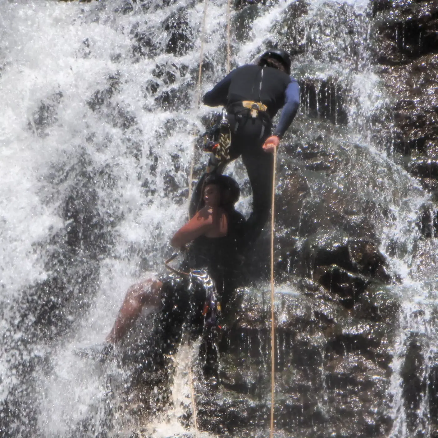 Rappelling down through the spray of a waterfall